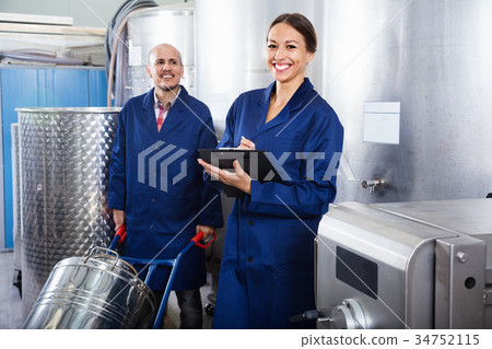 Woman holding cardboard and standing with man working Woman holding cardboard and standing with man working 34752115