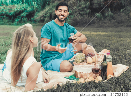 Couple are talking and drinking wine in time picnic outdoor 34752133