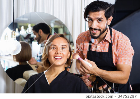 Man makeup artist applying cosmetics for woman Man makeup artist applying cosmetics for woman 34752287