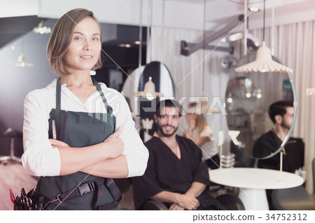 smiling woman hairdresser with male visitor 34752312