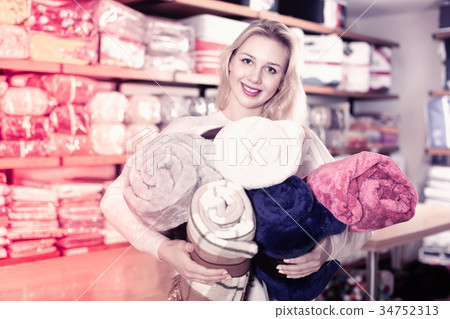 Young female customer boasting purchased home textiles 34752313