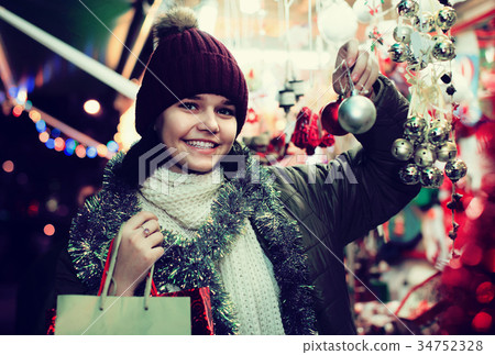 girl choosing Christmas decoration at market girl choosing Christmas decoration at market 34752328