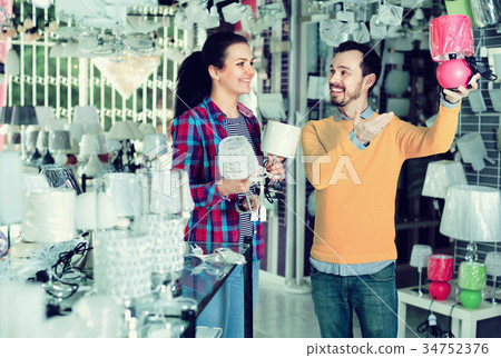Smiling man and girl in lighter shop discussing purchase of night light 34752376