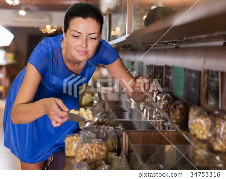 Woman taking nut beans in shop Woman taking nut beans in shop 34753316