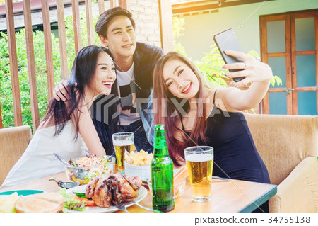 Group of friends are taking selfie and eating food Group of friends are taking selfie and eating food 34755138