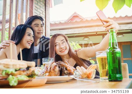 Group of friends are taking selfie and eating food Group of friends are taking selfie and eating food 34755139