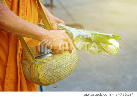 Monk is given food and lotus from Buddhist . 34756184