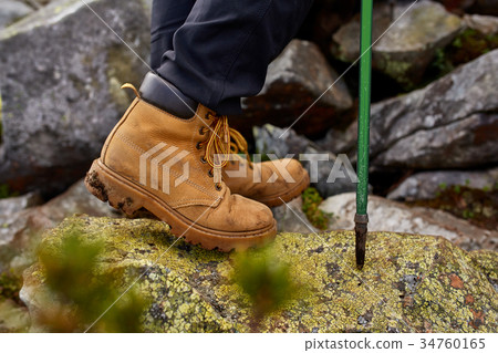 hiking boots close-up. girl tourist steps on the hiking boots close-up. girl tourist steps on the 34760165