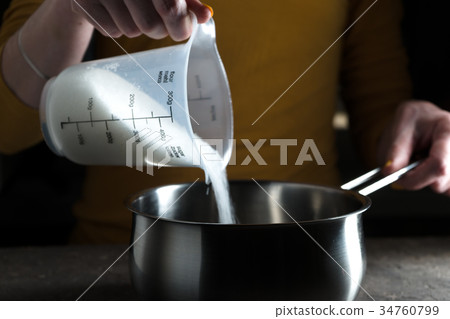 Sugar granulated sugar is poured into the saute 34760799