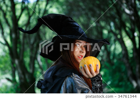 Photo of witch with pumpkin in hand 34761344