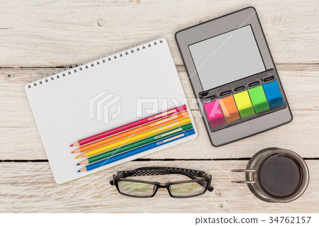 Top view: ebook, notebook and colored pencils Top view: ebook, notebook and colored pencils 34762157