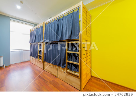 Hostel dormitory beds arranged in room 34762939