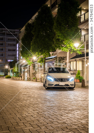 Cityscape at night with white car Cityscape at night with white car 34764033