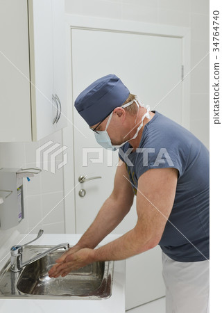 Male surgeon washing his hands before operation 34764740