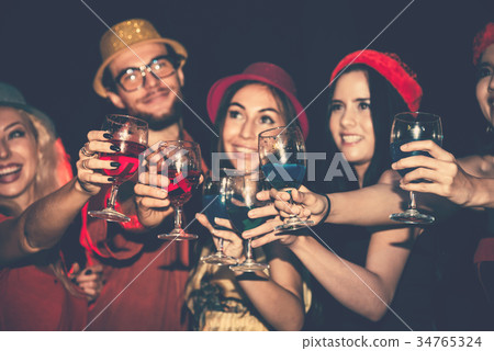 Cheerful Party of Friends Enjoying in Night Club Cheerful Party of Friends Enjoying in Night Club 34765324