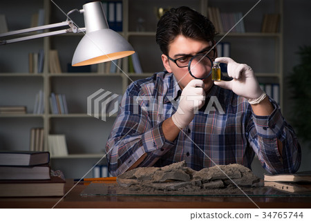 Archeologist working late night in office Archeologist working late night in office 34765744