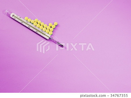 Traditional Medical thermometer and yellow pills 34767355