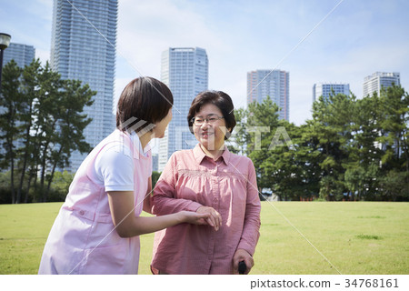 Smiling senior and helper to walk with a cane Smiling senior and helper to walk with a cane 34768161