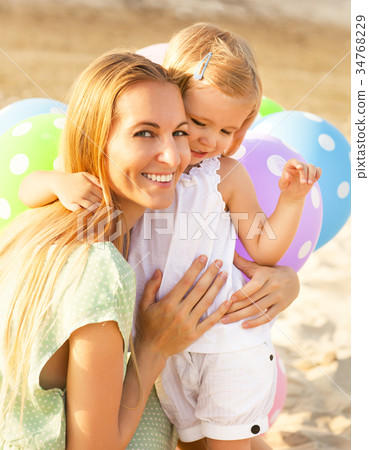 Happy woman and her little daughter outdoors Happy woman and her little daughter outdoors 34768229