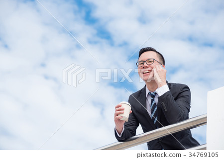 Young businessman wearing black suit smiling  34769105