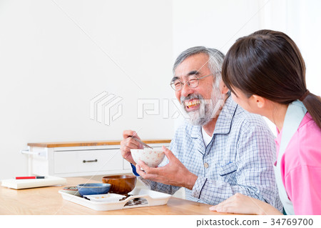 Young carer and grandpa enjoy meal conversation assistance nutrition management nursing home day care center Young carer and grandpa enjoy meal conversation assistance nutrition management nursing home day care center 34769700