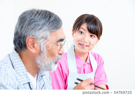 年輕看護者和祖父享受膳食對話協助營養管理療養院日託中心 年輕看護者和祖父享受膳食對話協助營養管理療養院日託中心 34769720