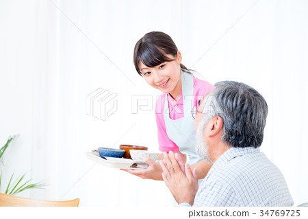 年輕看護者和祖父享受膳食對話協助營養管理療養院日託中心 年輕看護者和祖父享受膳食對話協助營養管理療養院日託中心 34769725