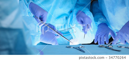 Group of surgeons at work while operating at 34770264