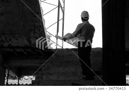 Engineer with blueprint in construction site 34770415