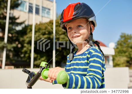 Boy in helmet standing with bike at autumn park Boy in helmet standing with bike at autumn park 34772996