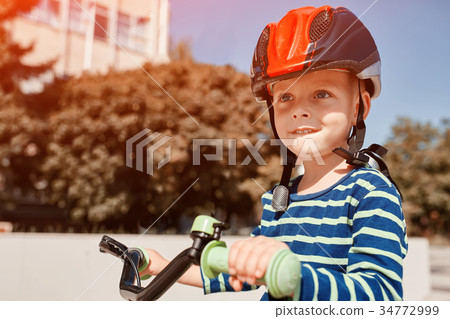 Boy in helmet standing with bike at autumn park Boy in helmet standing with bike at autumn park 34772999