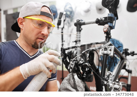 Mechanic repairing bicycle in his workshop 34773048