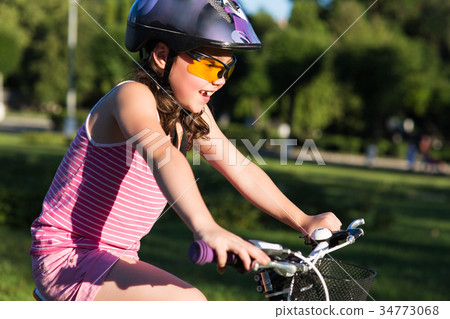 Portrait of a little girl in helmet on a bicycle 34773068