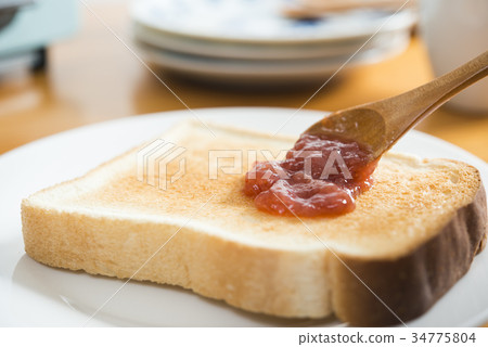 Apply jam to toast 34775804