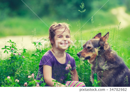 Happy little girl with dog on the clover lawn Happy little girl with dog on the clover lawn 34782982