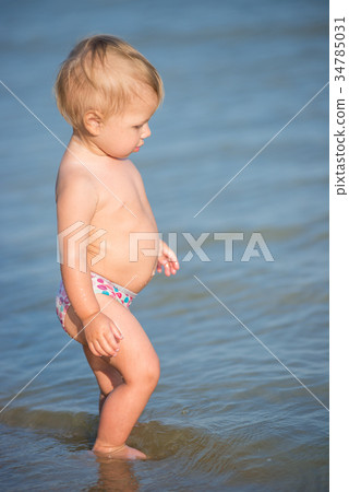 Cute baby playing on the sandy beach and in sea Cute baby playing on the sandy beach and in sea 34785031