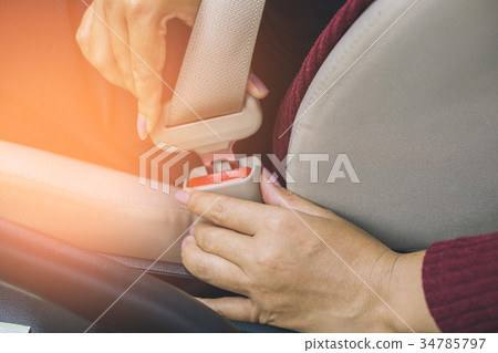 Asian woman hand fastening a seat belt  34785797