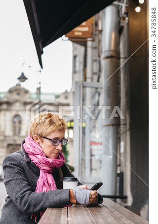 Woman browsing smartphone in outside cafe Woman browsing smartphone in outside cafe 34785848
