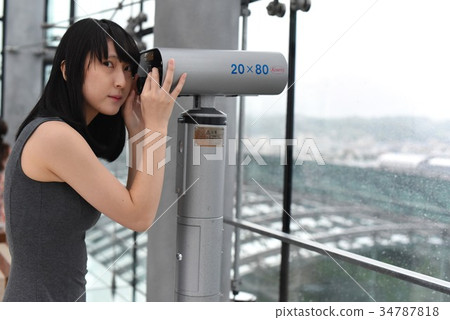 Girl looking through an aquarium telescope 34787818
