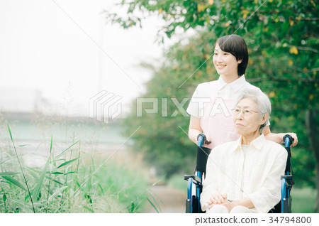 Senior and young carer in wheelchair Senior and young carer in wheelchair 34794800