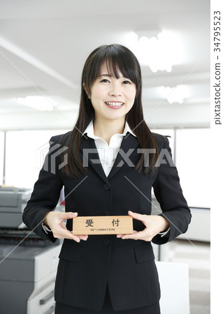 拿著接待員窗口微笑指導支持信息的板材婦女 拿著接待員窗口微笑指導支持信息的板材婦女 34795523