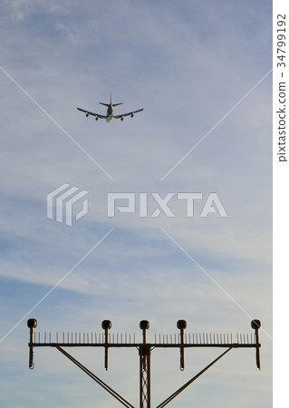 Airport landing lights with airplane approaching  34799192