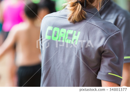 back of a coach's grey shirt with green word Coach back of a coach's grey shirt with green word Coach 34801377