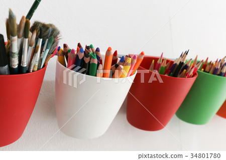 colorful pencils on white cup is hanged on the bar colorful pencils on white cup is hanged on the bar 34801780
