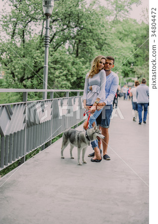 Beautiful young couple playing with a dog husky 34804472