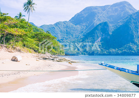 Banca boat at anchor in clear water at sandy Beach 34809877