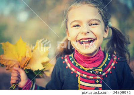 Happy little girl with autumn leaves Happy little girl with autumn leaves 34809975