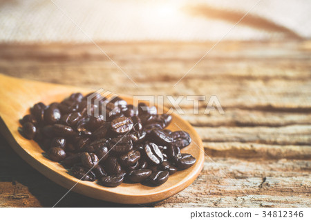 Close up of coffee beans on wooden spoon. Close up of coffee beans on wooden spoon. 34812346