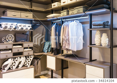 modern wooden wardrobe with cloth hanging on rail modern wooden wardrobe with cloth hanging on rail 34814104