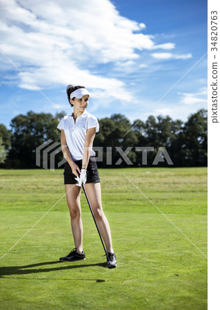 Pretty girl playing golf on grass 34820763